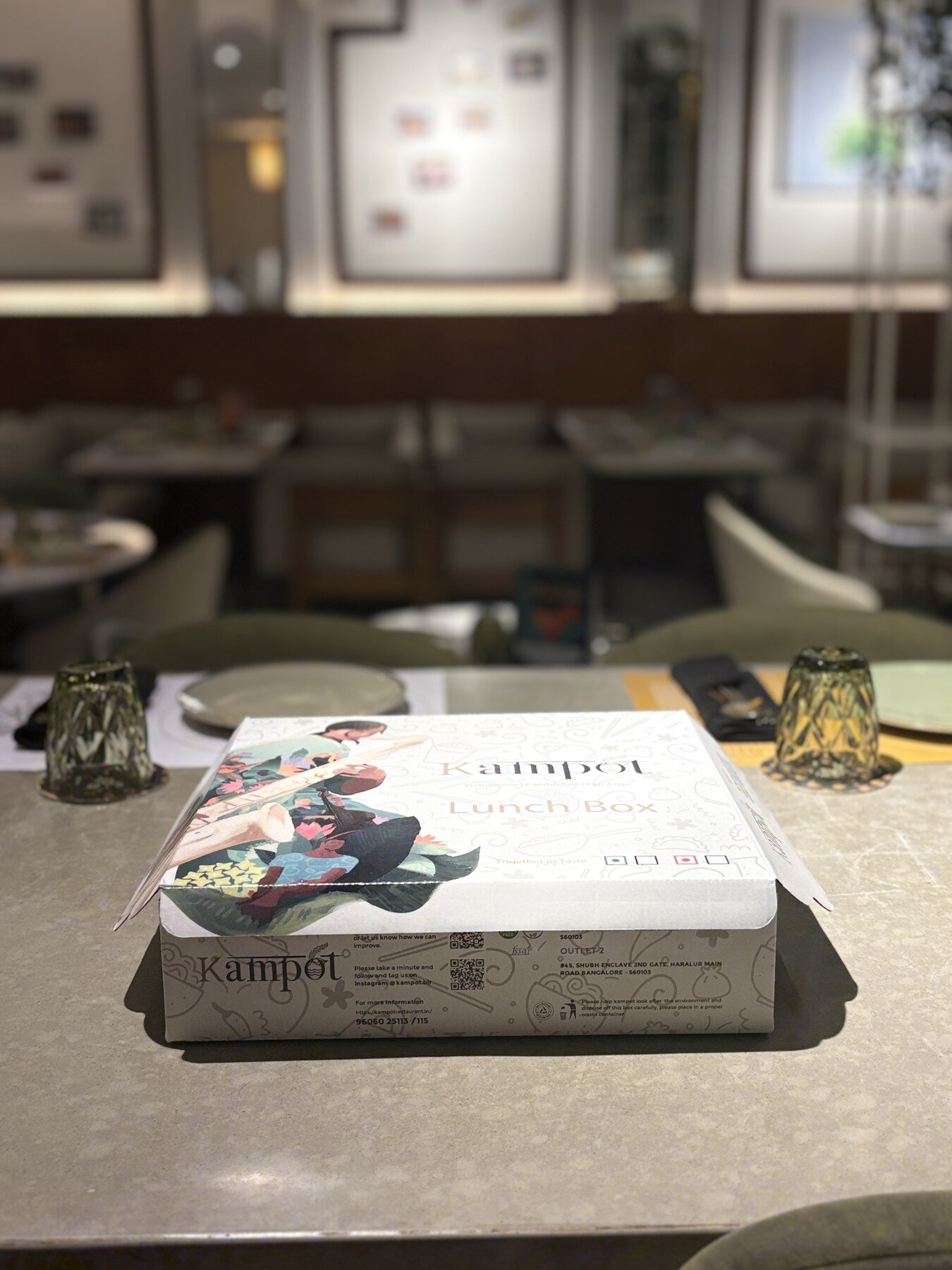 Kampot branded lunch box on a dining table inside the restaurant